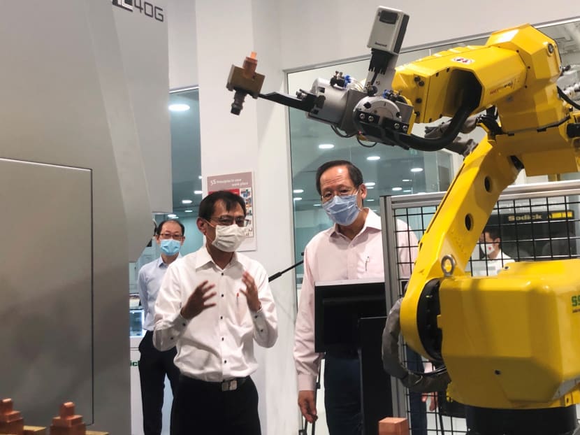 Second Minister for Trade and Industry Tan See Leng (right) being briefed by Sodick Singapore general manager Daniel Tan on the manufacturing firm’s processes at its technology centre in the Jurong Innovation District.