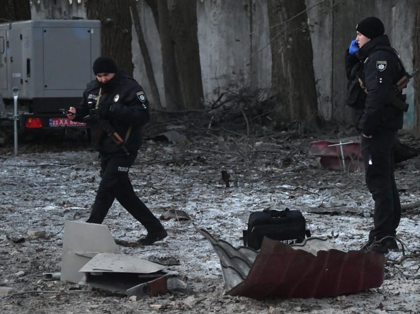Rescuers and police experts examine remains of a drone following a strike on an administrative building in the Ukrainian capital Kyiv on Dec 14, 2022. 
