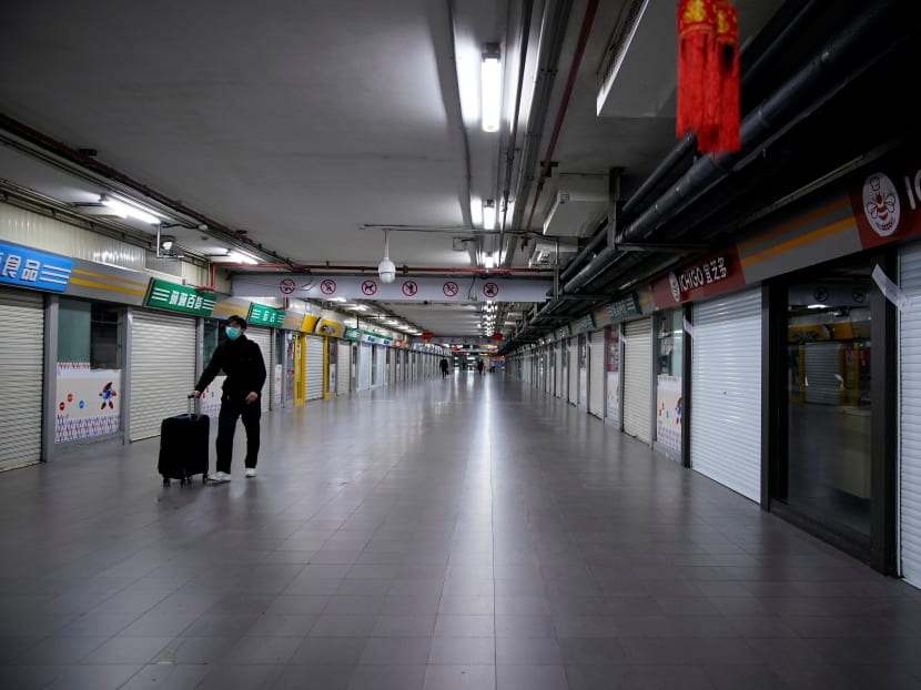 A man wearing a mask walks through closed stores in Shanghai on Feb 4. The author, a Singaporean living and working in Shanghai, describes how businesses have been affected by the novel coronavirus.