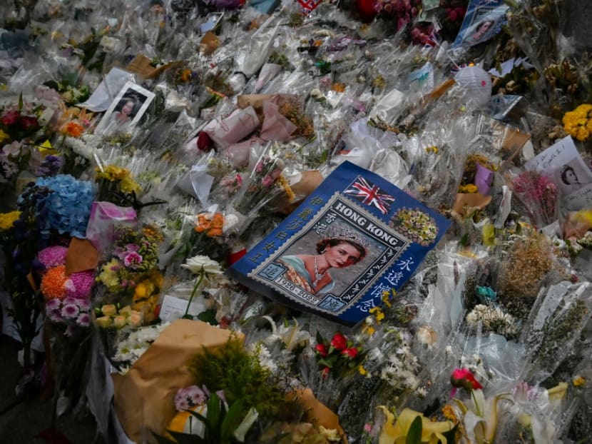 An image of Britain's Queen Elizabeth II is placed amongst flower tributes as people gather outside the British Consulate in Hong Kong on Sept 19, 2022, while her funeral was taking place in London. An image of Britain's Queen Elizabeth II is placed amongst flower tributes as people gather outside the British Consulate in Hong Kong on Sept 19, 2022, while her funeral was taking place in London.