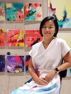 The writer, seen here with her paintings at Design Orchard, on Nov 24, 2021. 