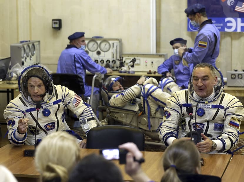 FILE - In this March 25, 2014 file photo, US astronaut Steven Swanson (left) and Russian cosmonaut Alexander Skvortsov (right), crew members of the mission to the International Space Station, speak with relatives during pre-launch preparations at the Russian-leased Baikonur cosmodrome in Kazakhstan. Photo: AP