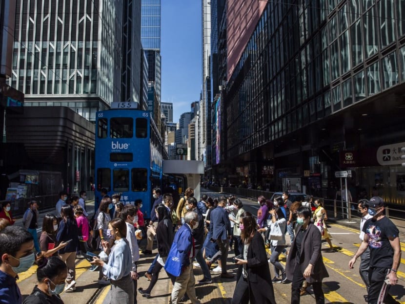 People cross a road in the Central district of Hong Kong on Oct 25, 2021.