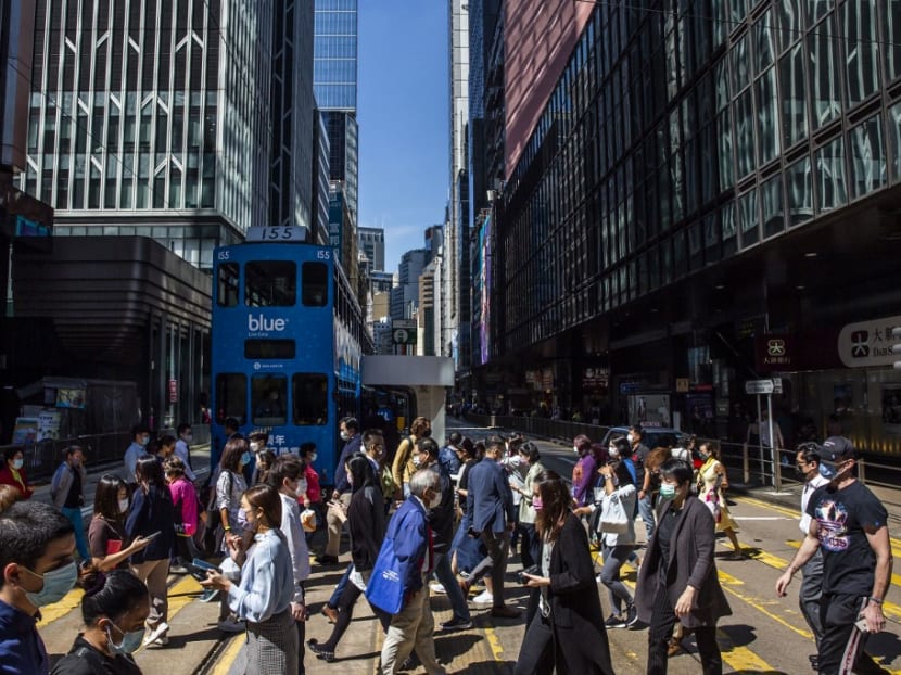 People cross a road in the Central district of Hong Kong on Oct 25, 2021. People cross a road in the Central district of Hong Kong on Oct 25, 2021.