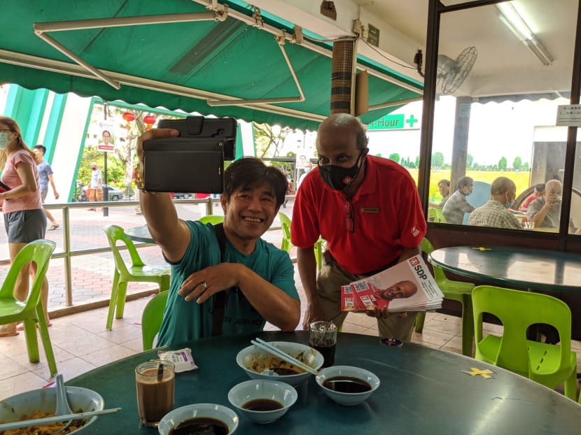 Dr Paul Tambyah (right) from the Singapore Democratic Party taking a selfie with a resident of Bukit Panjang during a walkabout on July 4, 2020.