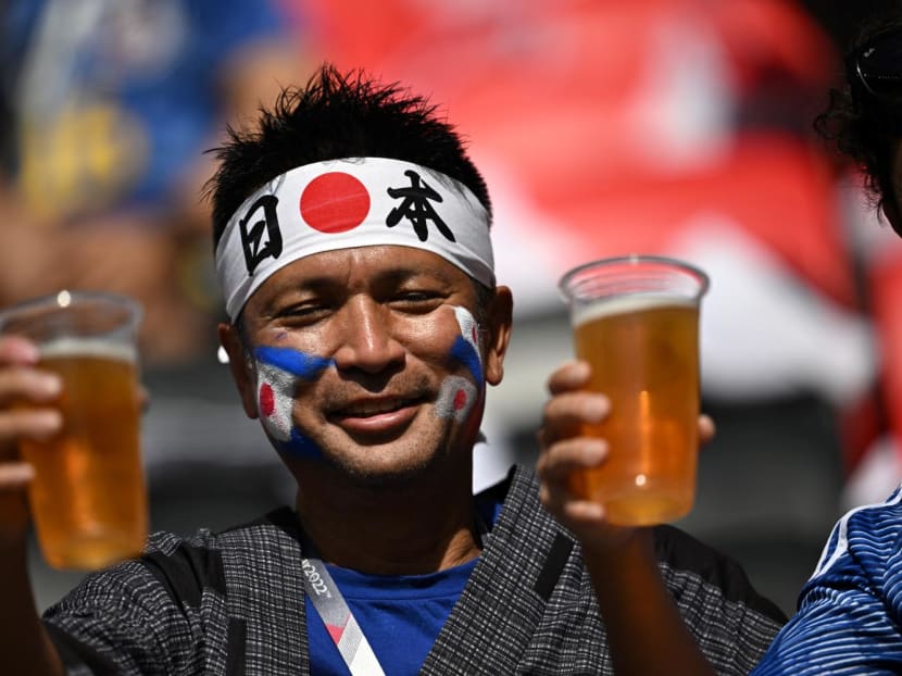 A Japan supporter holds up non-alcohol beer as he cheers ahead of the Qatar 2022 World Cup Group E football match between Japan and Costa Rica at the Ahmad Bin Ali Stadium in Al-Rayyan, west of Doha on Nov 27, 2022.
