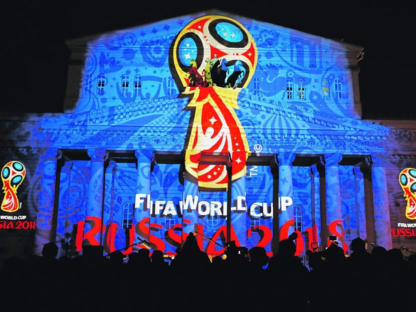 Journalists look at a light installation showing the official logotype of the 2018 FIFA World Cup during its unveiling ceremony at the Bolshoi Theater building in Moscow. REUTERS file photo