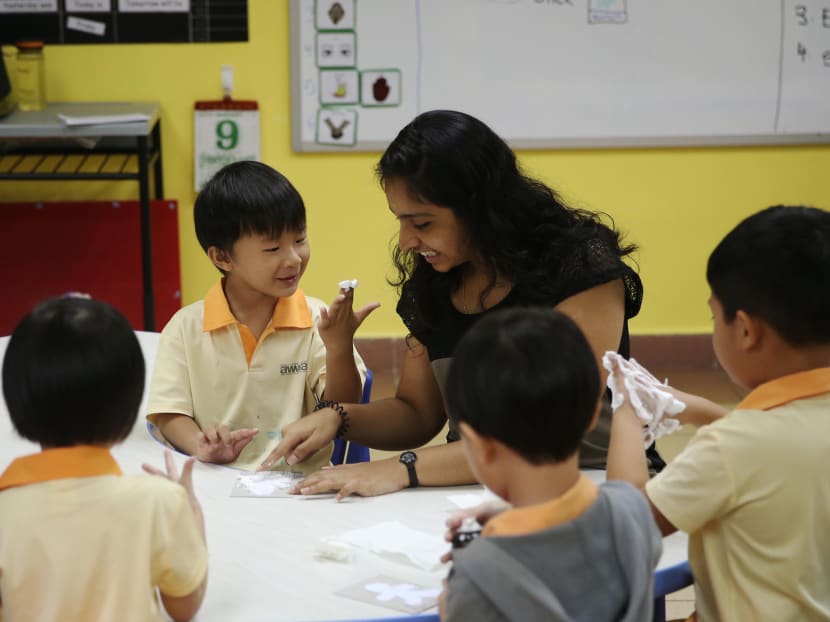 Chiam Tat Lui (centre), who has Global Developmental Delay is a student of AWWA Early Years Centre. He is pictured here doing arts and craft with teacher Ms Vidhya Nair on Jan 9, 2015. Photo: Wee Teck Hian