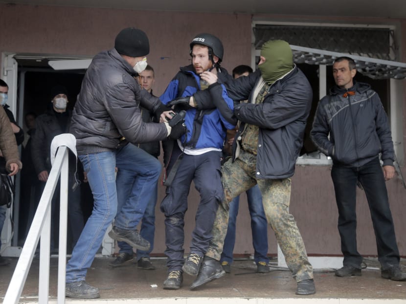 Masked pro-Russian men attack British photojournalist Frederick Paxton during the mass storming of a police station in the eastern Ukrainian town of Horlivka, April 14, 2014.   Photo: AP
