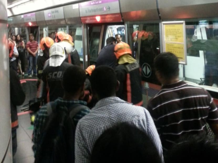 SCDF personnel helping the woman extricate her leg from the platform gap at Boon Keng MRT Station on May 14, 2015. Photo: Twitter/@estelledream
