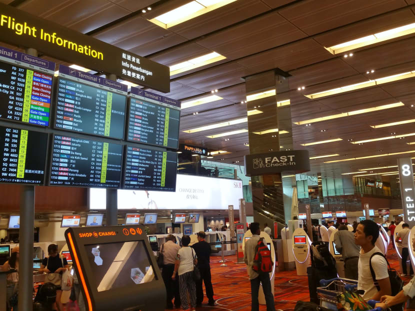 Passengers at the display board at Changi Airport Terminal 1. Photo: Christopher Toh
