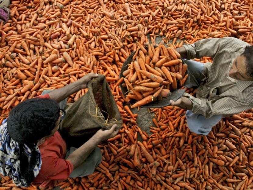 Labourers pack carrots into bags at a wholesale market in Jammu, India, Thursday, July 17, 2008. India's inflation rate reached 11.89 per cent for the week ended June 28, with wholesale prices-based inflation reaching a new 13-year high. AP FILE PHOTO