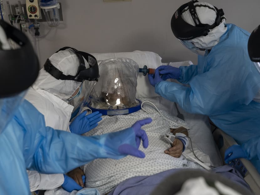 Members of the medical staff treat a patient who is wearing helmet-based ventilator in the Covid-19 intensive care unit at the United Memorial Medical Center on July 28, 2020 in Houston, Texas.