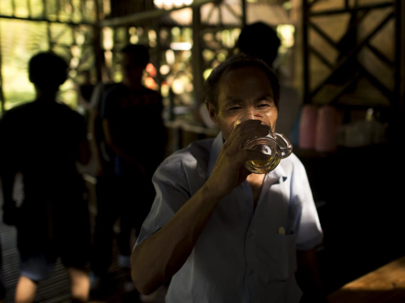 A man drinking bamboo liqueur at a bar in the Yibin bamboo forest on July 30, 2016. Photo: AFP