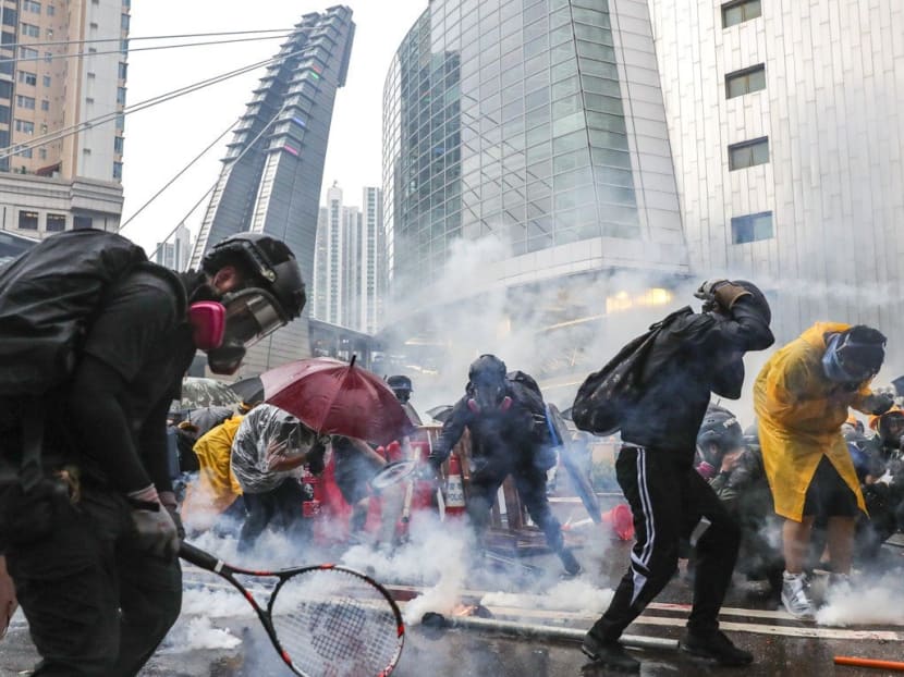 Protesters defend themselves against tear gas in Tsuen Wan during a standoff with police on August 25.