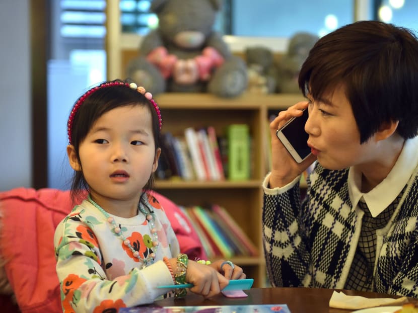 This picture taken on February 13, 2017 shows Kim Yu-Mi, a 38-year-old IT engineer, and her young daughter during an interview with AFP at a cafe in Seongnam, south of Seoul. South Korea's massive, 90 billion USD campaign to encourage more women to have babies is considered a failure with its birthrate stubbornly remaining one of the world's lowest for years. Photo: AFP