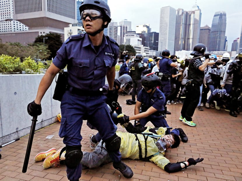 Police officers arresting a pro-democracy protester outside government headquarters in Hong Kong yesterday. Photo: AP