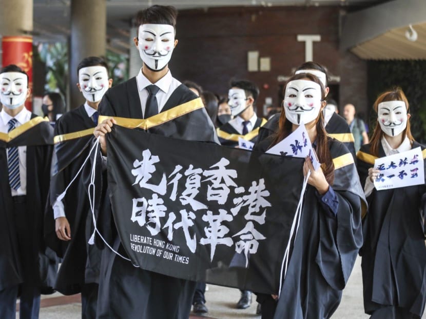 Hong Kong Polytechnic University students wear Guy Fawkes masks and chant slogans before their graduation ceremony on Nov 5.