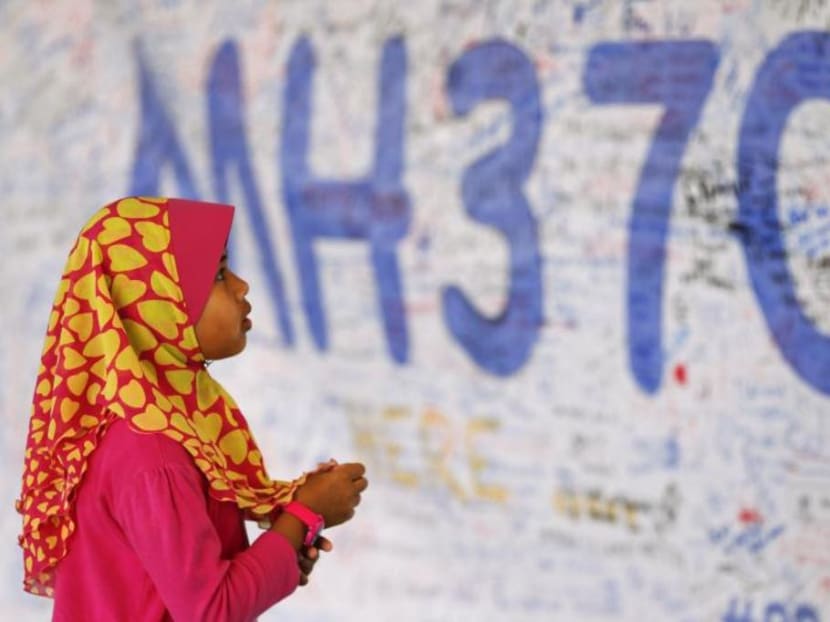 A girl looks at a board with messages of support and hope for passengers of the missing Malaysia Airlines MH370.
