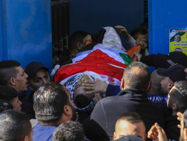 Palestinians carry the body of one of the nine victims killed during an Israeli raid on the West Bank's Jenin refugee camp as they begin a funeral procession in Jenin on Jan 26, 2023.