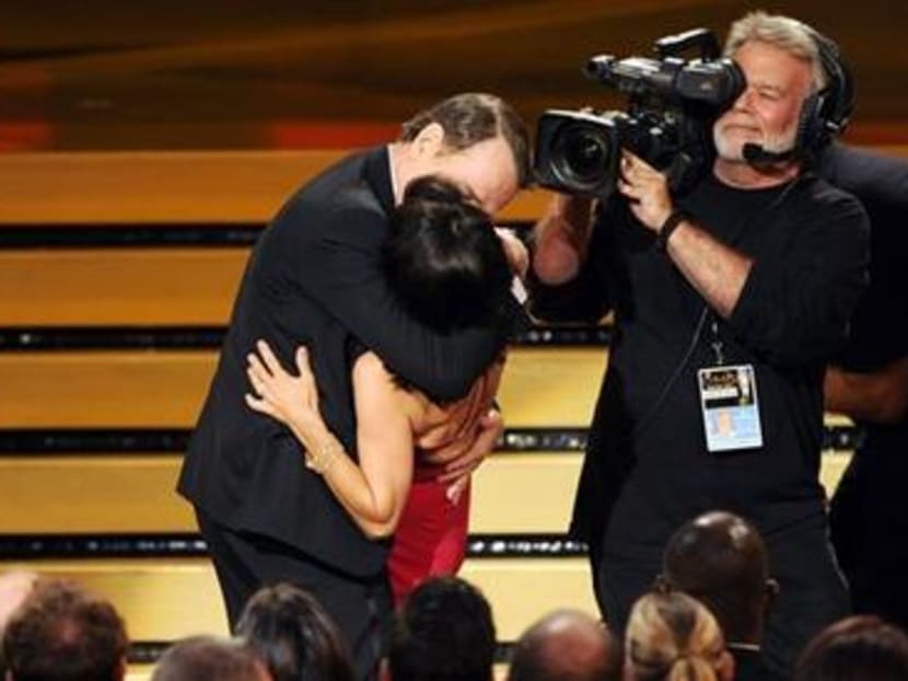 Bryan Cranston kisses Julia Louis-Dreyfus as she accepts the award for outstanding lead actress in a comedy series for her work on “Veep” at the 66th Annual Primetime Emmy Awards on Monday, Aug 25, 2014, in Los Angeles. Photo: AP