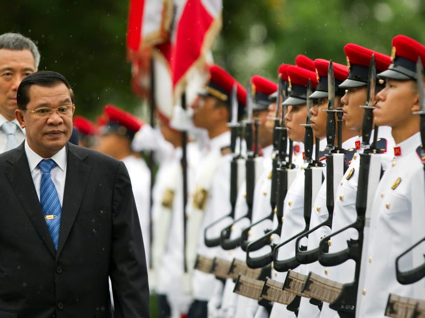Cambodia's Prime Minister Hun Sen (front) inspecting an honour guard as Singapore's Prime Minister Lee Hsien Loong walks behind him at the Istana in Singapore, during a three-day official visit on July 26, 2010.