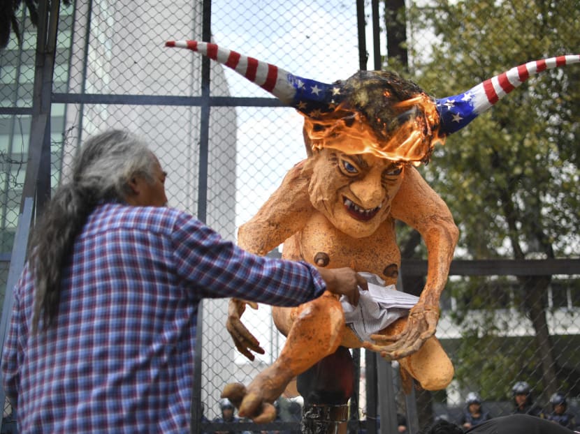 A Mexican burn an "Alebrije", traditional Mexican figure, with the face of US President Donald Trump in front of the US embassy building during a protest against the wall between Mexico and the US borders, in Mexico City on Jan 31, 2017. Photo: AFP