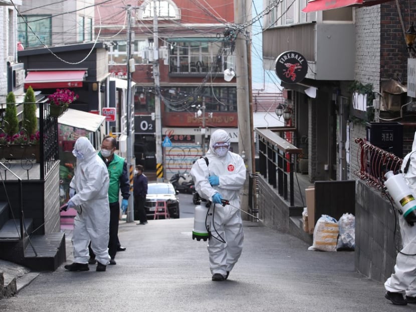 Health workers spray disinfectant on a street in the Itaewon district of Seoul on May 12, 2020. Health workers spray disinfectant on a street in the Itaewon district of Seoul on May 12, 2020.