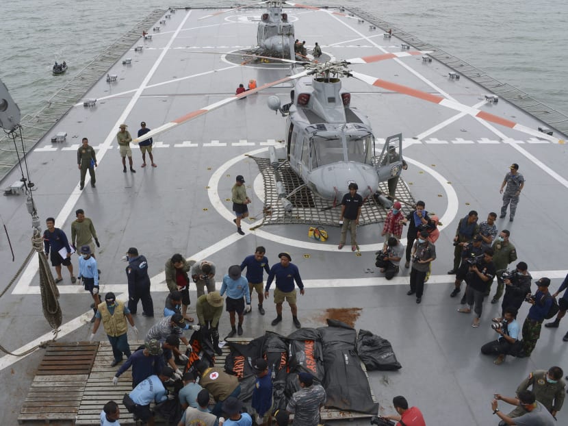 Indonesian Navy personnel lay recovered dead bodies from AirAsia flight QZ8501 on the the deck of the Indonesian Navy vessel KRI Banda Aceh, at sea January 3, 2015. Ships searching for the wreck of an AirAsia passenger jet that crashed with 162 people on board have pinpointed two "big objects" on the sea floor, the head of Indonesia's search and rescue agency said on Saturday. Photo: Reuters
