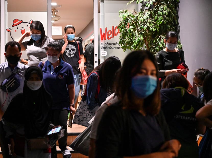 Department store employees wearing face masks leaving after work in Bangkok on May 30, 2020.