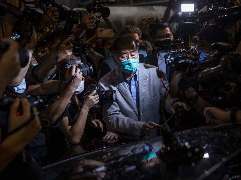 Hong Kong pro-democracy media mogul Jimmy Lai (centre) pushes through a media pack to get to a waiting vehicle after being released on bail from the Mong Kok police station in the early morning in Hong Kong on Aug 12, 2020.