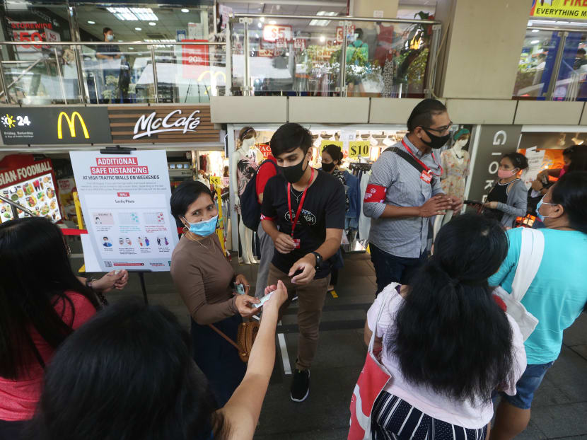 Safe-distancing enforcement officers checking the National Registration Identity Cards and Foreign Identification Numbers of visitors entering Lucky Plaza shopping centre on Sept 6, 2020.