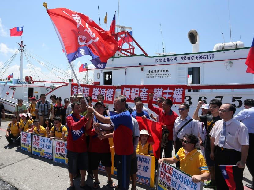 Taiwanese fishermen display flags and placards before departing to Taiping island, part of the disputed Spratly Islands chain in the South China Sea, at a fishing harbour in southern Pingtung on July 20, 2016. Photo: AFP