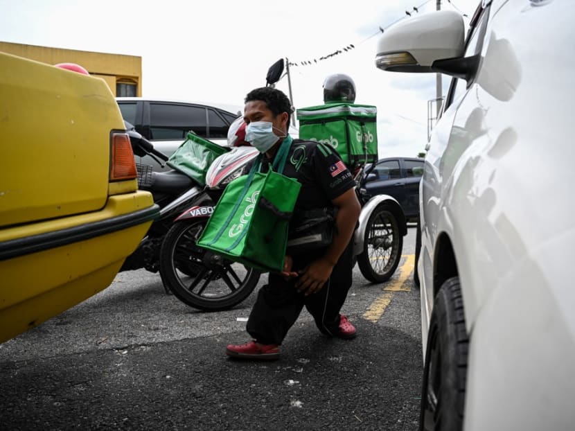 This picture taken on Nov 25, 2020 shows Mr Muhammad Sidek Osman, a Grab food delivery man born disabled due to birth complications, walking towards a restaurant to pick up orders in Gombak, on the outskirts of Kuala Lumpur.