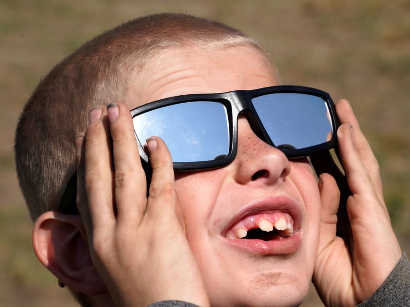 A boy trying out his new solar glasses in a designated eclipse viewing area at a campground near Guernsey, Wyoming, US, on August 20, 2017. Photo: Reuters