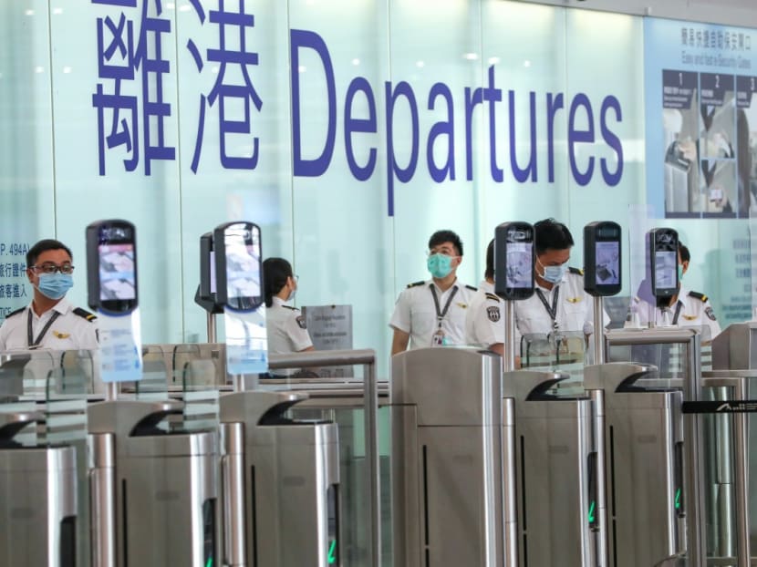 Security staff guard an empty departure gate at Hong Kong International Airport amid the coronavirus pandemic.