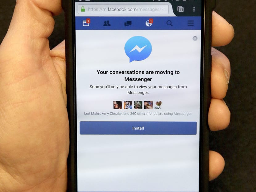 An Associated Press reporter holds a mobile phone showing the Facebook Messenger app installation page in San Francisco, Wednesday, July 27, 2016. Photo: AP