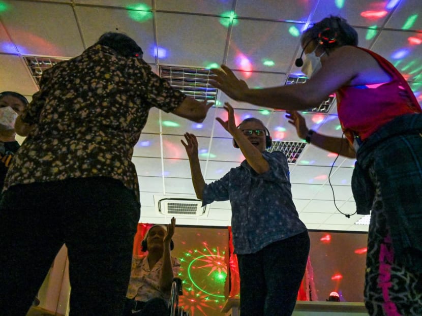 Residents with dementia participating in a silent disco at Apex Harmony Lodge in Singapore on May 12. Under flashing disco lights, residents with dementia held hands and danced to golden oldies at a Singapore care home under an initiative to help those with the disorder.