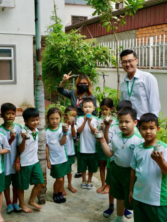 Mr Wang Junyong, 32, is a managing director of an international school in Cambodia. He is seen here with some K2 students and a teacher during an outdoor activity.  