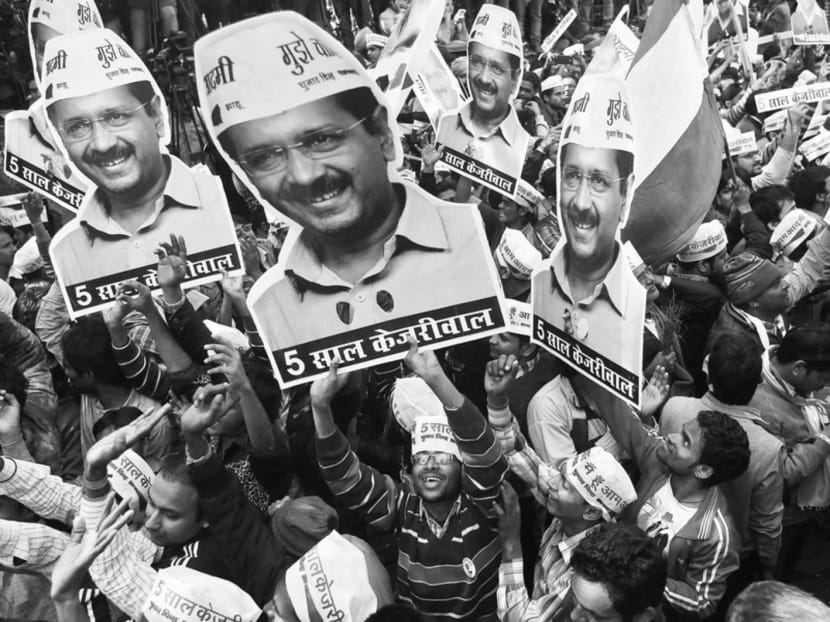AAP supporters holding portraits of Mr Arvind Kejriwal during post-election celebrations on Tuesday. Mr Kejriwal has emerged as the face of the opposition to the Prime Minister. Photo: Reuters