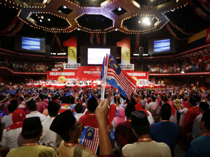 UMNO members waves flags as they sing parties song during the opening ceremony of Malaysia's ruling party UMNO 68th General Assembly in Kuala Lumpur, Malaysia yesterday. Photo: AP