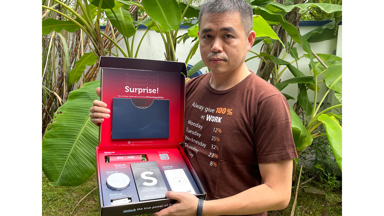 Mr Sherwin Teo unboxing the Singtel PowerUp 5G Kit that comprises a Samsung S21 Ultra 5G handset, a power bank, a thumb drive, a portable speaker and an energy bar.
