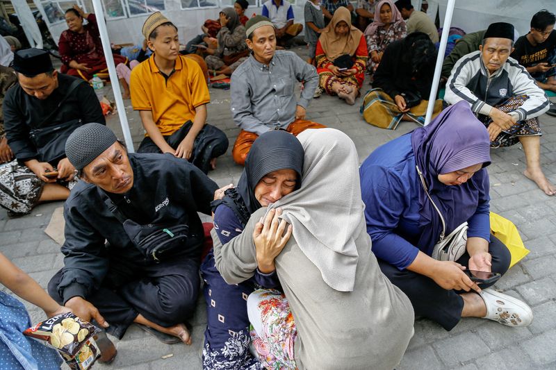 Relatives weep for scores of missing children after deadly Indonesia school collapse