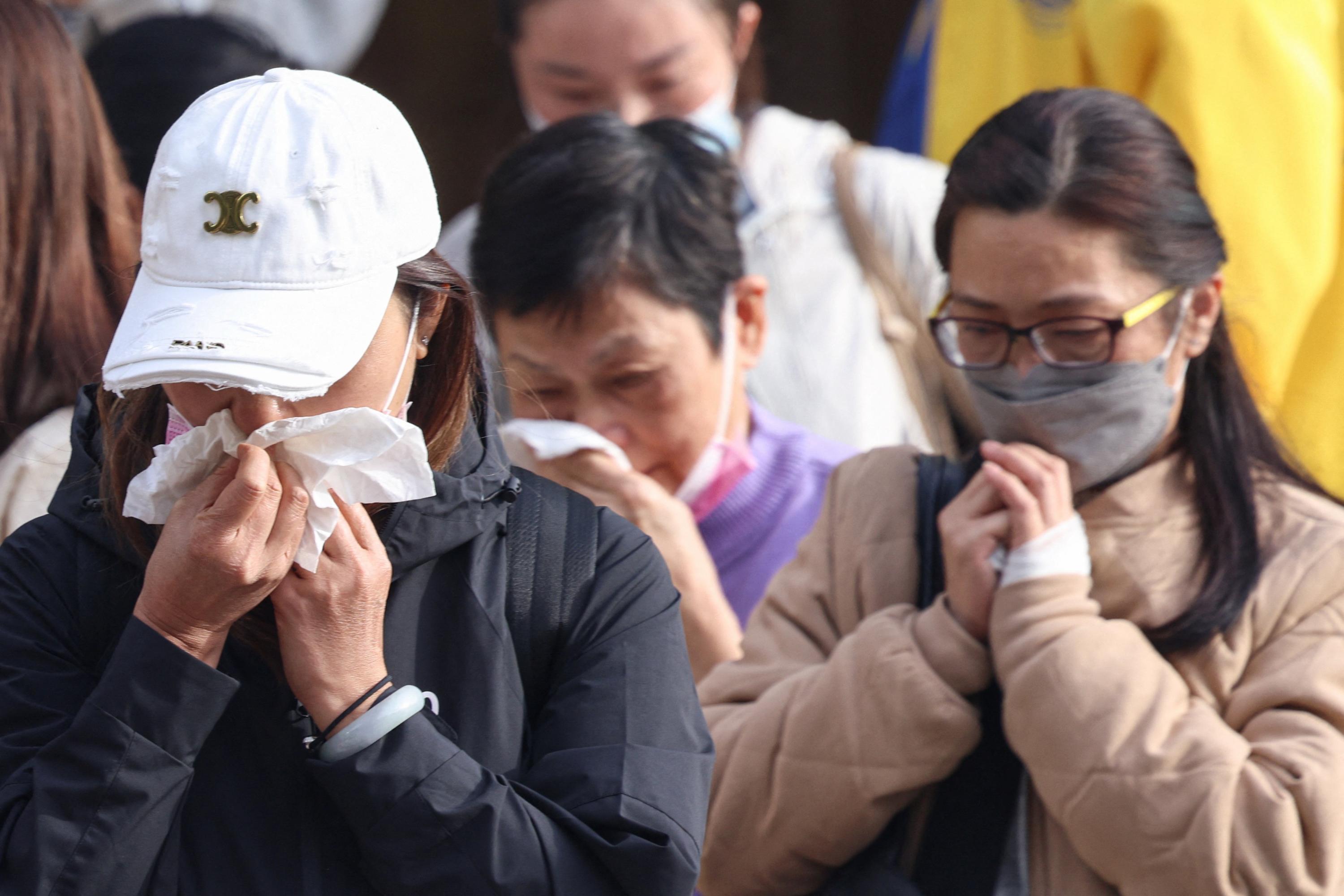 Grieving Hong Kong families search stark photos for fire victims