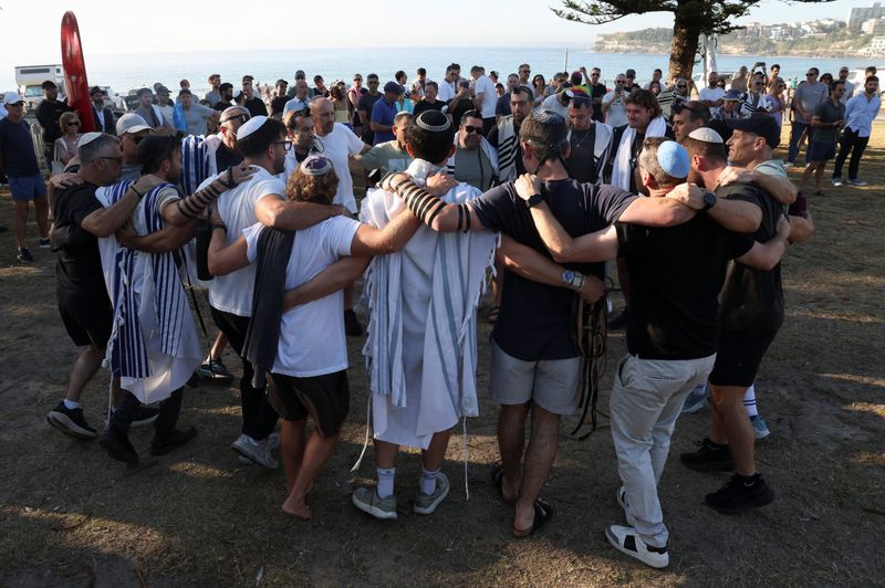 Australian Jews hold prayers, hundreds of surfers paddle out at Bondi to honour shooting victims