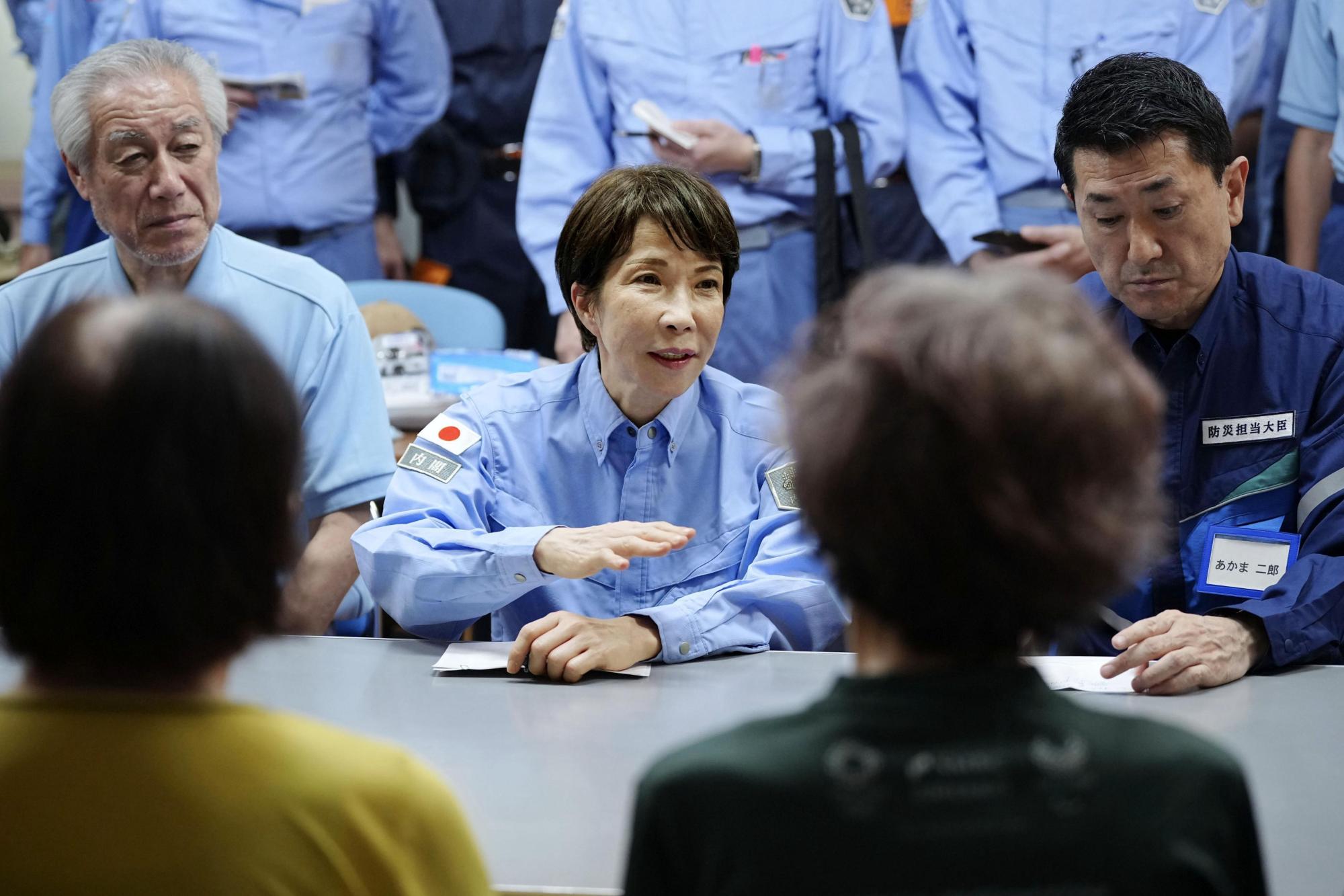 Japanese PM Takaichi visits quake-hit southern region as cleanup begins in intense heat