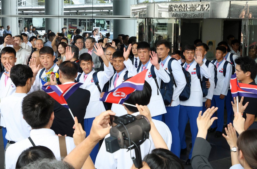 White blazers, pink ties as North Koreans land in Japan for Asian Games